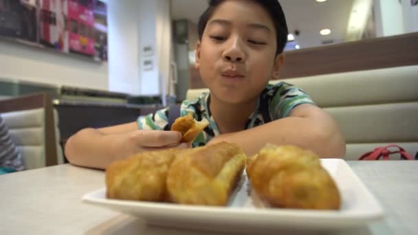 Happy asian preteens boy enjoy eating in morning breakfast. — Stock Video