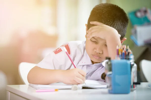 Giovane asiatico ragazzo doing suo homework — Foto Stock