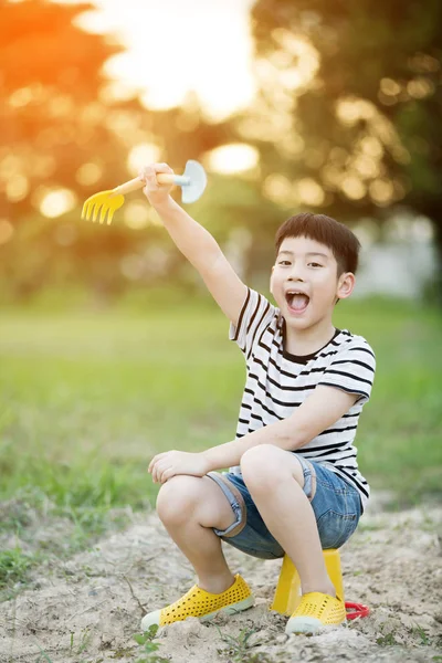 Азиатский мальчик играет с игрушками в саду — стоковое фото