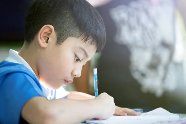 Young asian boy doing his homework — Stock Photo, Image