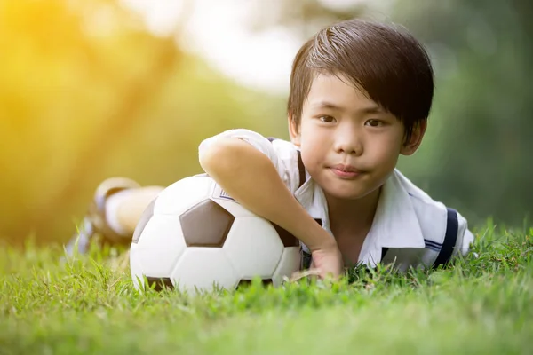 Piccolo ragazzo asiatico con calcio al parco — Foto Stock
