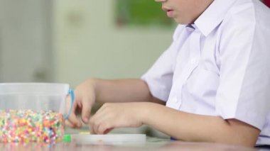 Okulda, oyun plastik oyuncaklar ile Asya sevimli çocuk sanat saat.