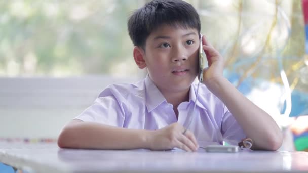 Feliz niño asiático usando un teléfono celular llamando con mamá  . — Vídeo de stock
