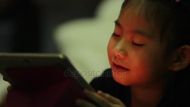 Glückliches asiatisches Kind schaut Bildschirm auf Tablet-Computer zu Hause — Stockvideo