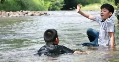 Mutlu iki Asyalı çocuk şelale Tayland oynarken