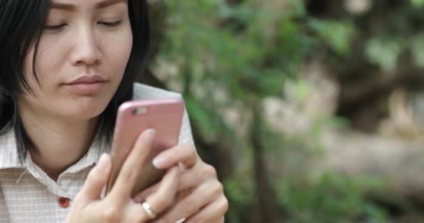 Woman using app on smartphone at forest in thailand — Stock Video