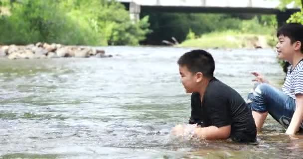 Щасливі два азіатських хлопчик грає водоспад в Таїланді — стокове відео