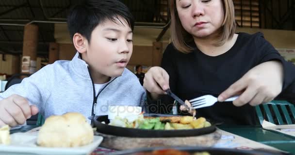 Asiatische Junge mit Mutter genießen Essen zu Hause — Stockvideo