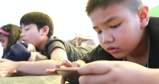 Heureux asiatique garçon et fille jouer téléphone intelligent et tablette dans camping zone — Video