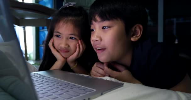 4 k 幸せなアジア子自宅のテーブルの下のコンピューターを見て — ストック動画