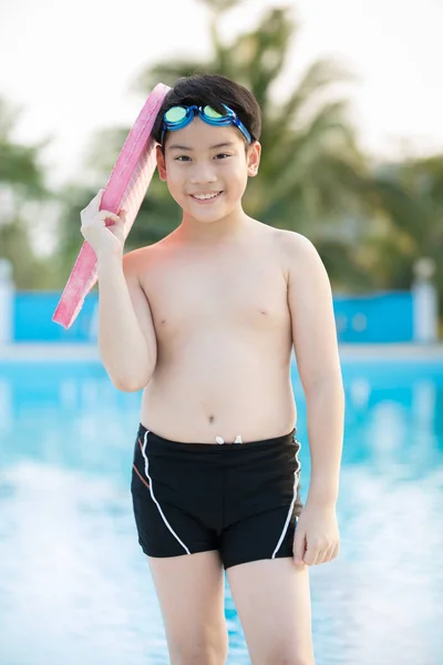 Feliz asiático chico en traje de baño subiendo hasta la piscina — Foto de Stock