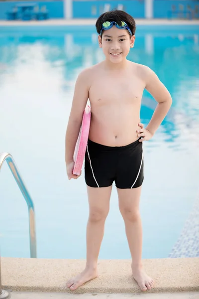 Feliz asiático chico en traje de baño subiendo hasta la piscina — Foto de Stock