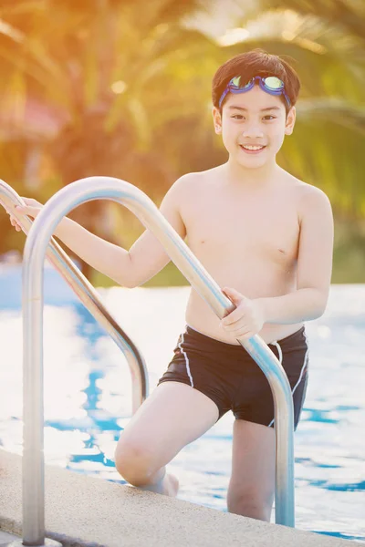 Feliz asiático chico en traje de baño subiendo hasta la piscina — Foto de Stock