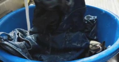 Asyalı kadın evinin önünde el ile çamaşır el
