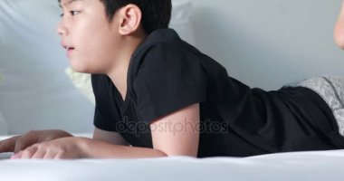 Akşamları onun yatakta yatan bilgisayar oyunları oynayan 9 yaşındaki eski çocuk çehresini closeup. Çocuk evde dizüstü bilgisayar ile.