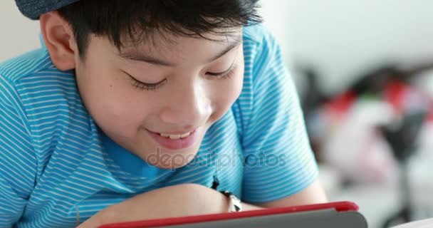 Крупный план лица 9-летнего ребенка, играющего в компьютерные игры, лежащего в постели вечером . — стоковое видео