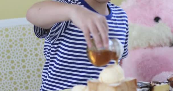 Boy vierte jarabe de miel con postre dulce . — Vídeos de Stock