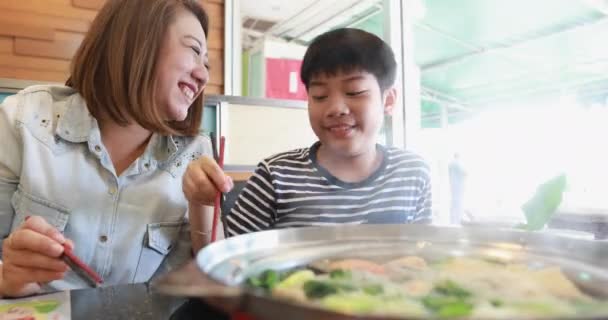 Щаслива азіатська сім'я мати і син насолоджуються їжею — стокове відео