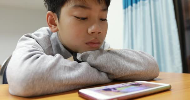 Niño pequeño viendo vídeo en un teléfono móvil — Vídeos de Stock