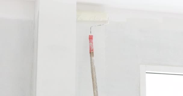 Hand holding a paint roller and painting ceiling, Close-up — Stock Video