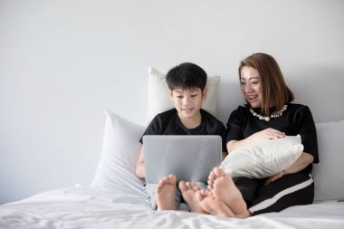 Anne ile oğlu oturan üzerinde yatak ve ev Laptop istimal ergenlik