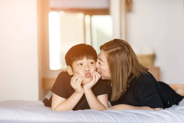 Мати цілує сина в спальні — стокове фото