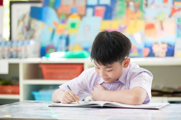 Felice asiatico bambino scrittura libro con sorriso faccia . — Foto Stock