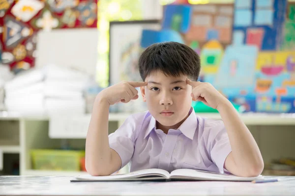Szczęśliwe dziecko Azjatki, czytanie książki i myśląc o tym — Zdjęcie stockowe