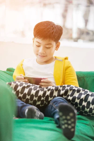 アジアの少年の幸せな笑顔で携帯電話を使用して . — ストック写真