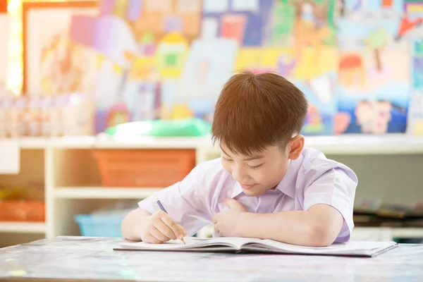 Felice asiatico bambino scrittura libro con sorriso faccia . — Foto Stock