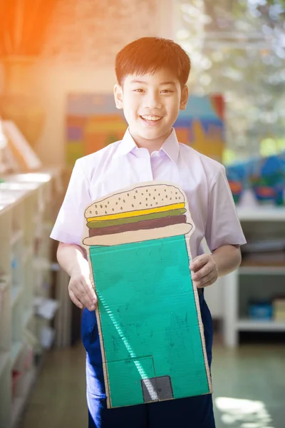 Šťastné Asijské dítě Ukázat své řemeslo a vypadající fotoaparát — Stock fotografie