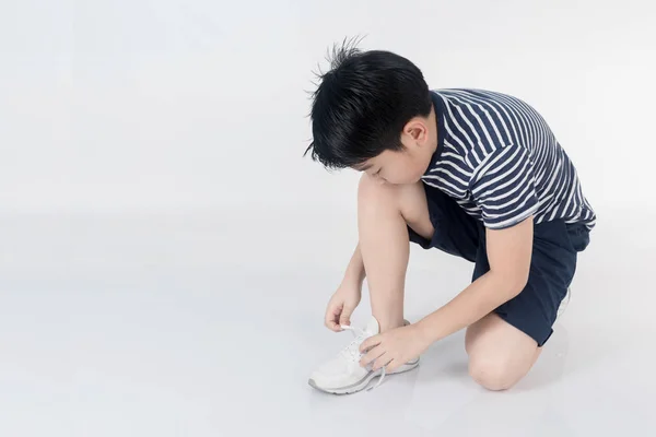 Portrét Asijské dítě snaží dát své boty . — Stock fotografie