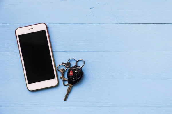 Téléphone portable et clés de voiture à distance sur fond en bois — Photo