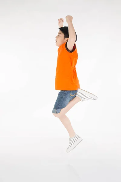 Asiático bonito menino está pulando com sorriso rosto — Fotografia de Stock