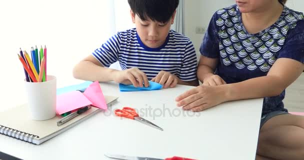 Niño asiático aprendiendo a doblar origami de papel japonés con madre, arte de doblar papel . — Vídeo de stock