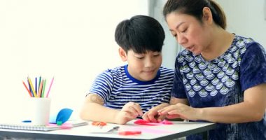 Asyalı çocuk anne ile kağıt katlama sanatı Japon kağıt origami katlama için öğrenme.