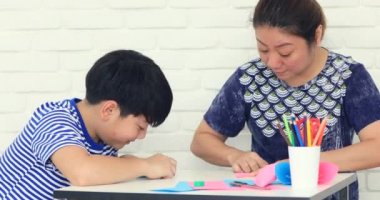 Asyalı çocuk anne ile kağıt katlama sanatı Japon kağıt origami katlama için öğrenme.