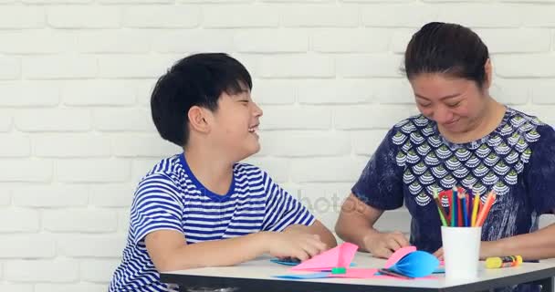 Asyalı çocuk anne ile kağıt katlama sanatı Japon kağıt origami katlama için öğrenme. — Stok video