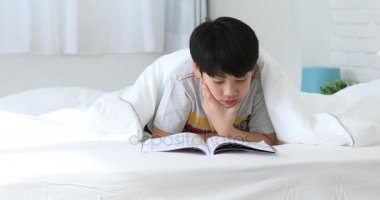 Asya sevimli çocuk dinlenme yatağı ve son test evde önce bir kitap okuma .