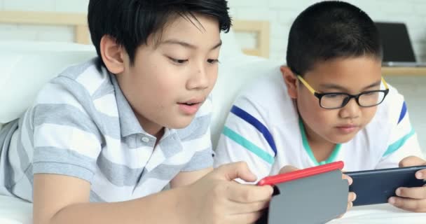 Felice preteen asiatico utilizzando dispositivi digitali sul tavolo della stazione di lavoro a casa . — Video Stock