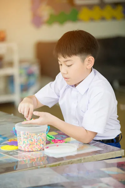 Bonito ásia menino jogar com plástico blocos no classe quarto no scho — Fotografia de Stock