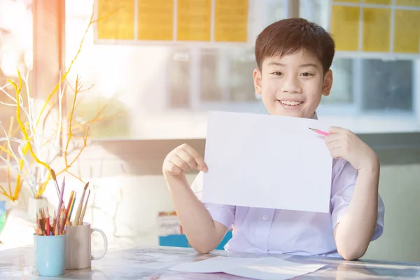 Feliz asiático chico mano celebración en blanco A4 hoja de papel y mirando — Foto de Stock