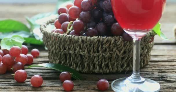 Glas Rotwein und Trauben auf altem Holzgrund. Selektiver Fokus — Stockvideo