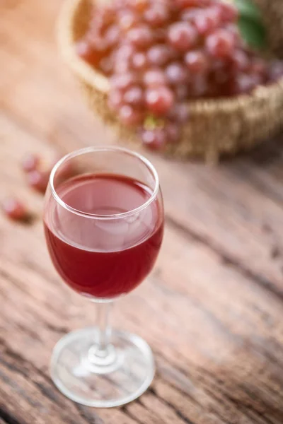 Glas Wein oder Traubensaft und Obst auf Holztisch — Stockfoto