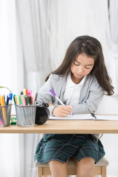 Χαριτωμένο κορίτσι της Ασίας κάτι γραπτώς σε χαρτί με μολύβια χρώματος — Φωτογραφία Αρχείου