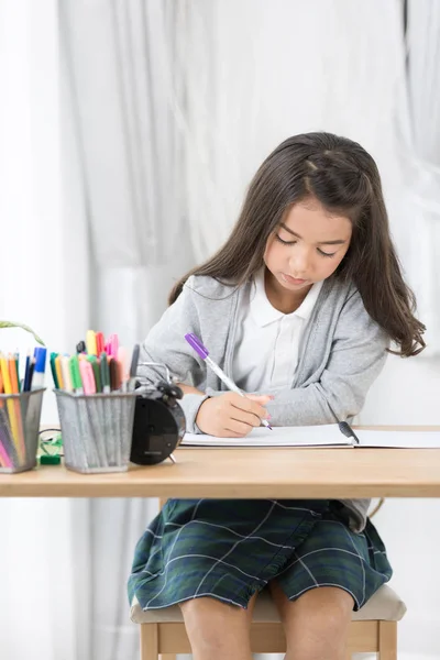 Carino Asia ragazza scrivere qualcosa in carta con matite di colore — Foto Stock