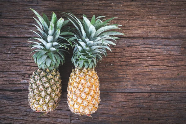 Dojrzałe ananasy na starym drewnianym stole — Zdjęcie stockowe
