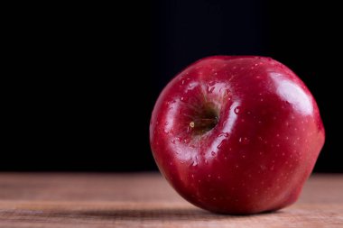 Olgun ahşap arka plan üzerinde Su damlacıkları ile kırmızı elma