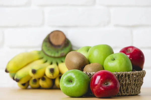 Čerstvé kiwi, jablka a banány na dřevěné pozadí — Stock fotografie