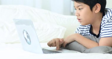 Sevimli Asya çocuk el daktilo gülümsemek yüz ile dizüstü klavye.